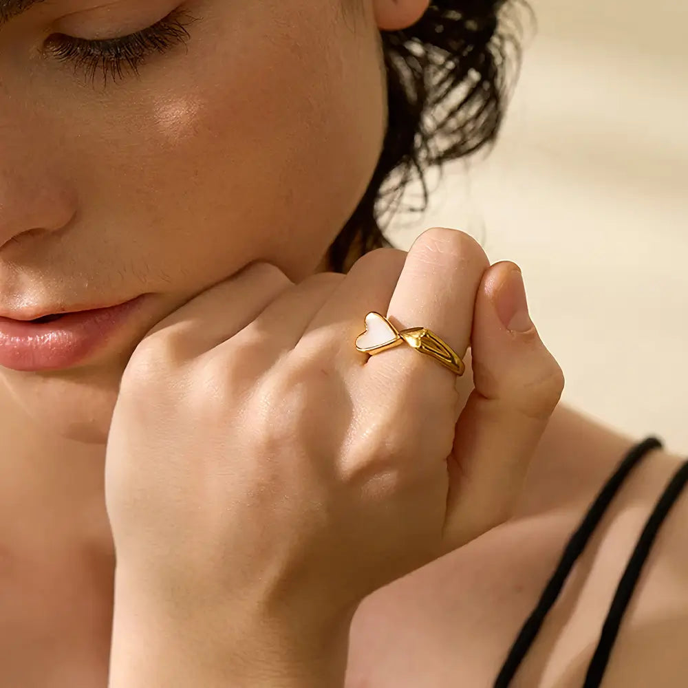 Foto de perto de uma mulher usando o Anel Feminino Dourado Ajustável com Coração de Concha Natural Coralina - Banhado a Ouro 18k