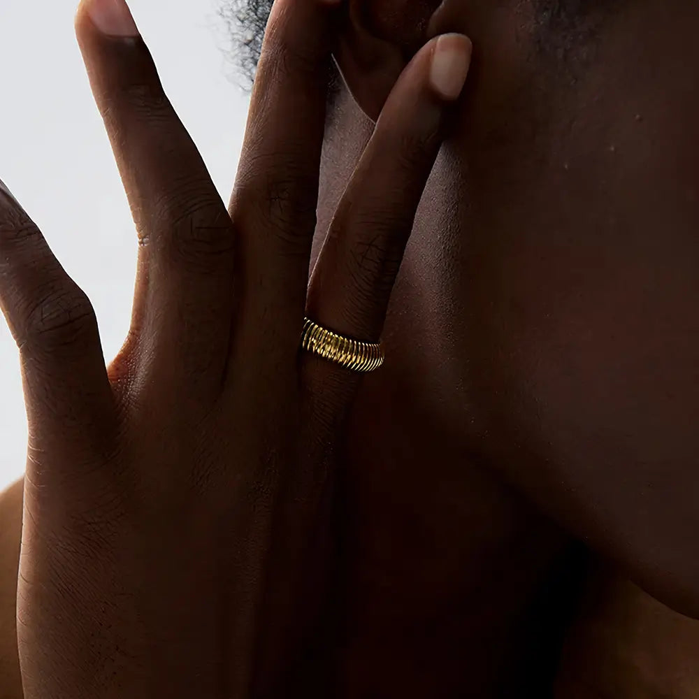 Foto de perto de uma mulher usando Anel Feminino Dourado Enrolado Ajustável Alúria - Banhado a Ouro 18k