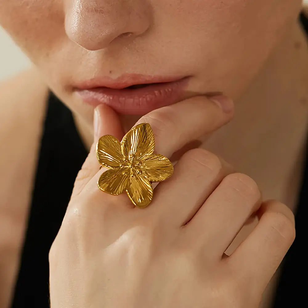 Foto de perto de uma Mulher usando o Anel Feminino Dourado Flor de 5 Pétalas Ajustável Florença - Banhado a Ouro 18k
