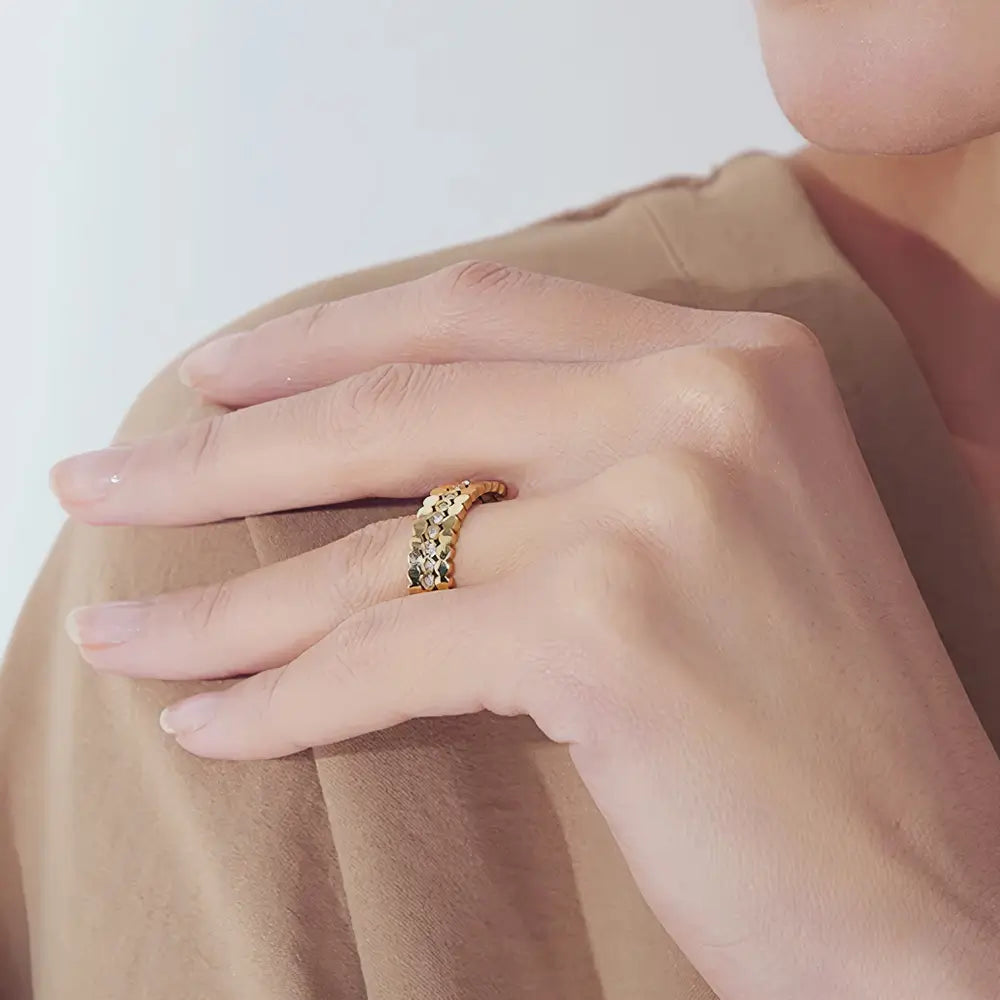 Foto close da mão de uma Mulher usando o Anel Feminino Dourado Triplo Ondulado com Zircônias Cúbicas Luminara - Banhado a Ouro 18k