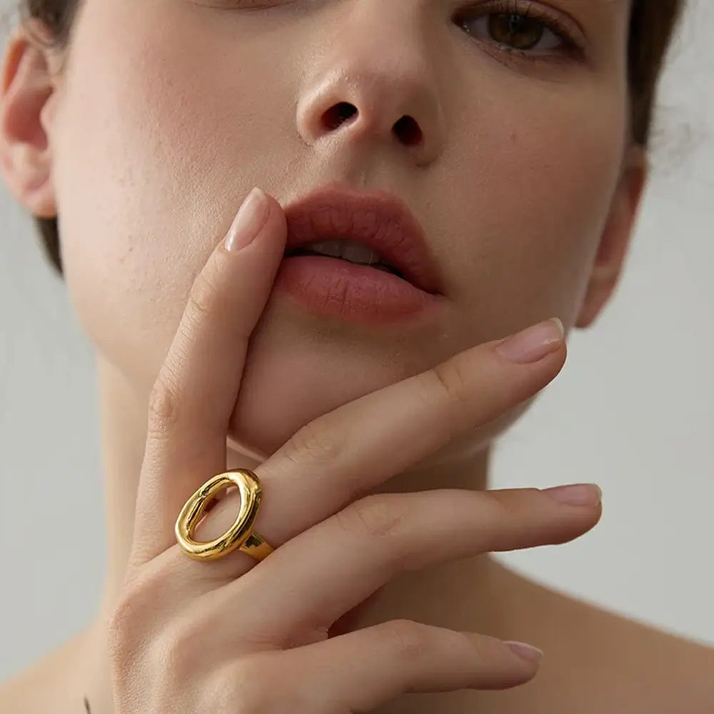 Foto de perto da Mulher usando o Anel Feminino Dourado com Circulo Irregular Aurélia - Banhado a Ouro 18k, mão