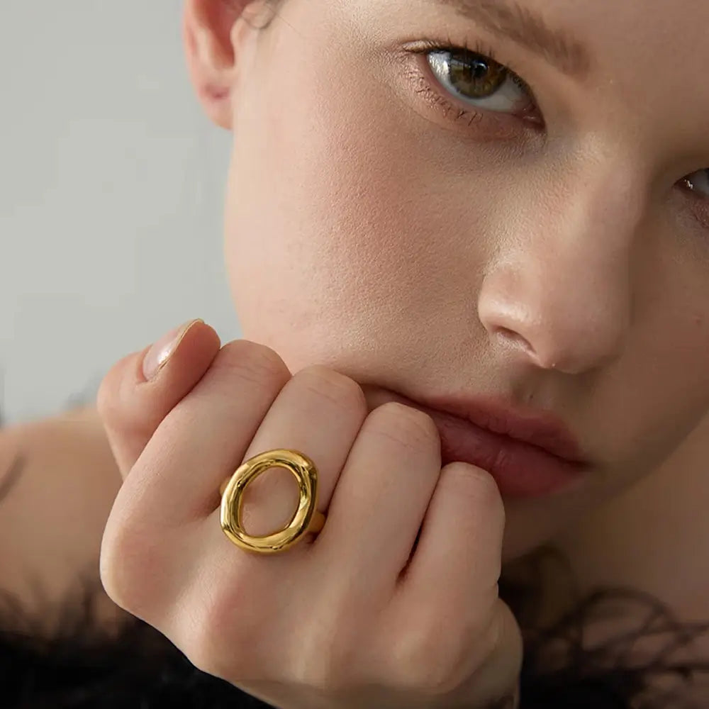 Foto de perto da Mulher usando o Anel Feminino Dourado com Circulo Irregular Aurélia - Banhado a Ouro 18k, mão fechada