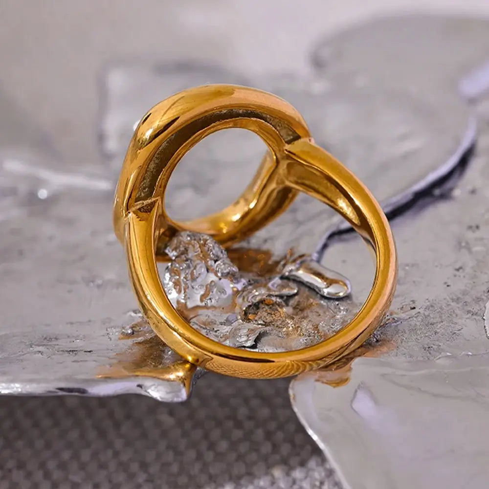 Anel Feminino Dourado com Circulo Irregular Aurélia - Banhado a Ouro 18k, fundo neutro metálico
