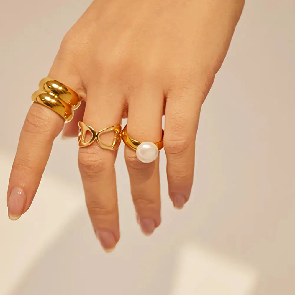 Foto de perto de uma mão feminina usando o Anel Solitário Dourado com Pérola Liora - Banhado a Ouro 18k