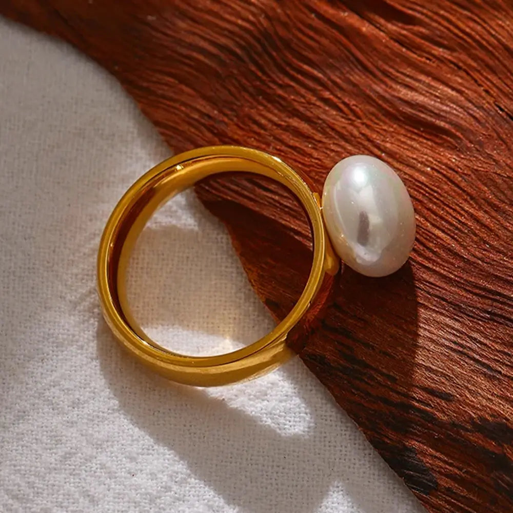 Anel Solitário Dourado com Pérola Liora - Banhado a Ouro 18k, apoiado em madeira marrom
