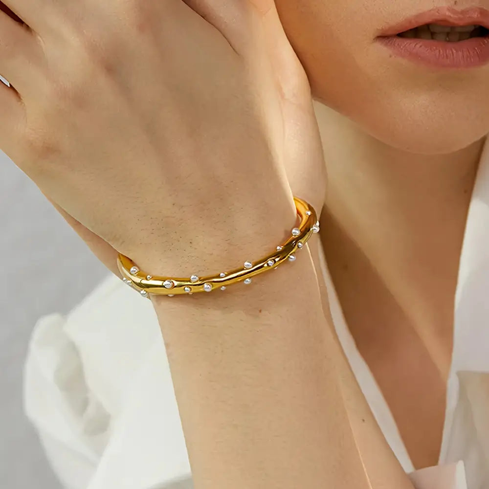 Bracelete Dourado Feminino cravejado com pérolas ajustável com design clássico