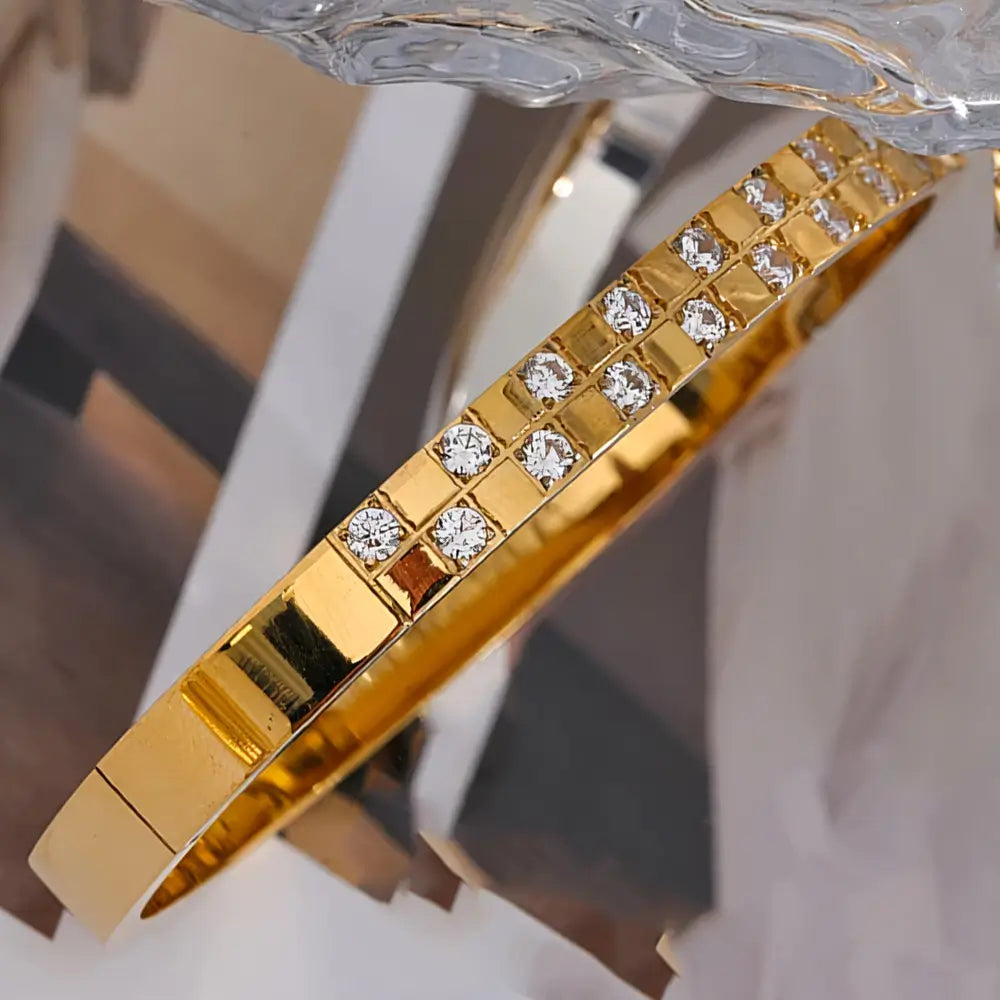 Bracelete Dourado Feminino cravejado com zircônias Seraphina, luminosidade destacada em cenário discreto