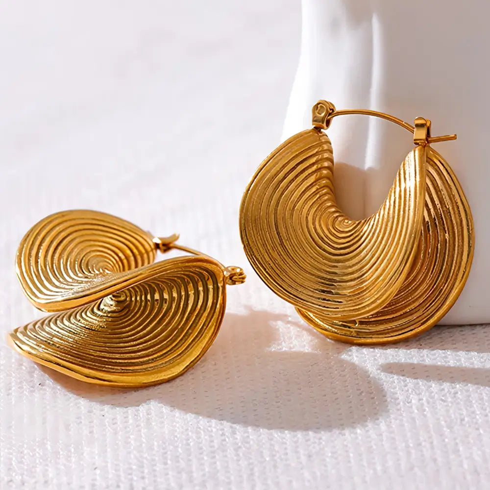 Brinco Feminino Dourado minimalista com forma circular em ambiente claro e discreto