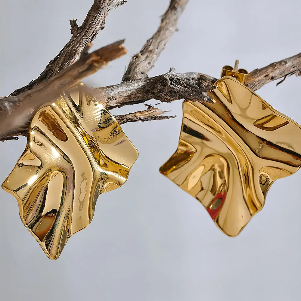Brinco Feminino Dourado quadrado ondulado com brilho delicado em fundo neutro