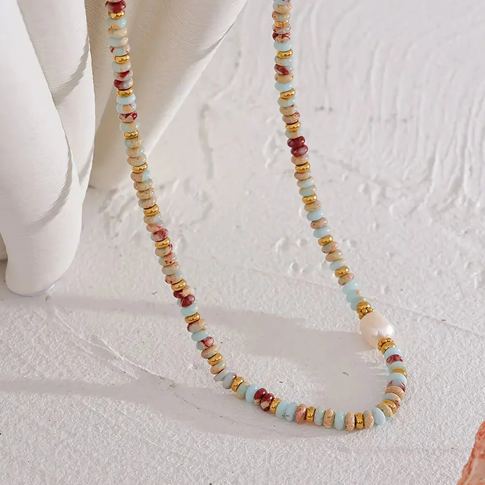 Colar Feminino de Pedras Naturais com pérola e contas douradas em ambiente claro e elegante