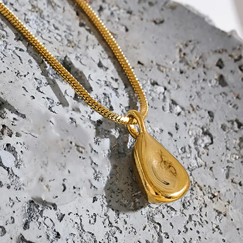 Colar Feminino Dourado corrente rabo de rato com pingente abstrato em ambiente clean e estilo contemporâneo