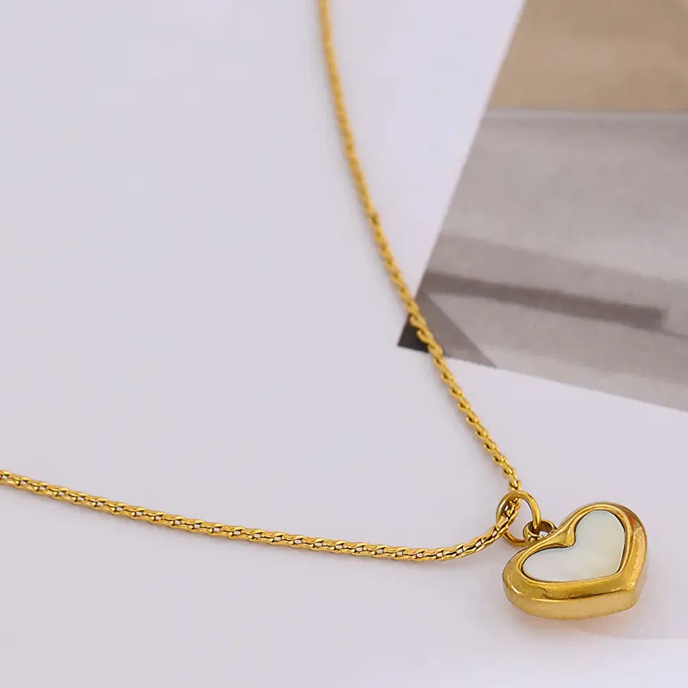 Colar Feminino Dourado de coração com concha natural Marena em ambiente clean e toque natural