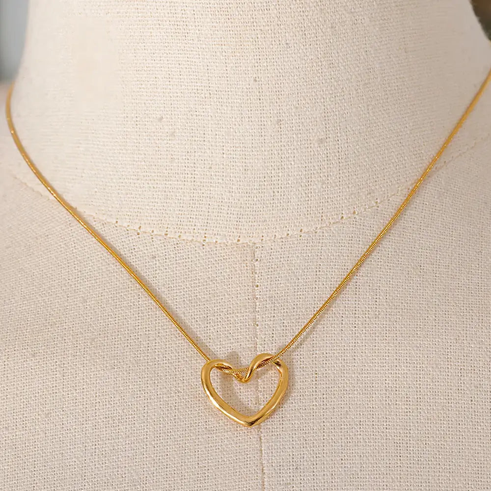 Colar Feminino Dourado de coração com corrente rabo de rato Amélia em fundo neutro e estilo clean