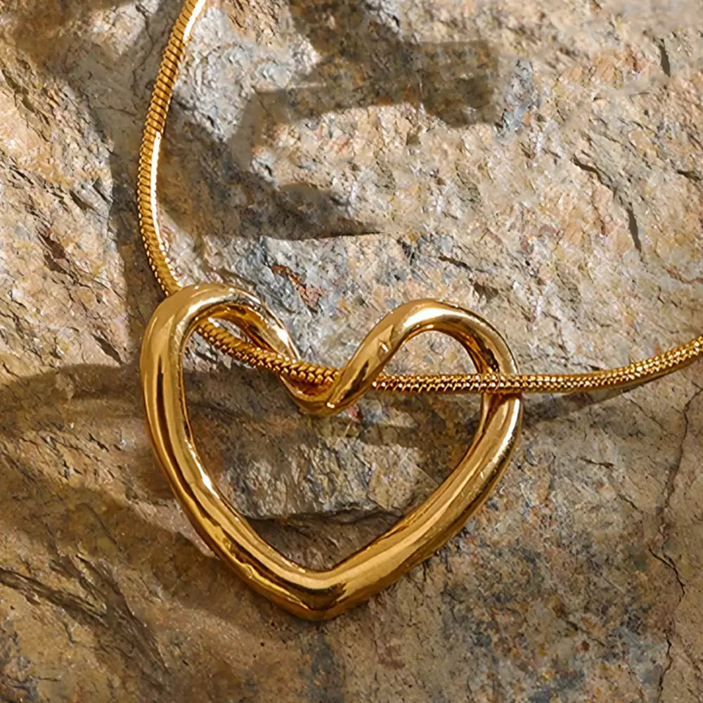 Colar Feminino Dourado de coração com corrente rabo de rato em cenário suave e textura refinada