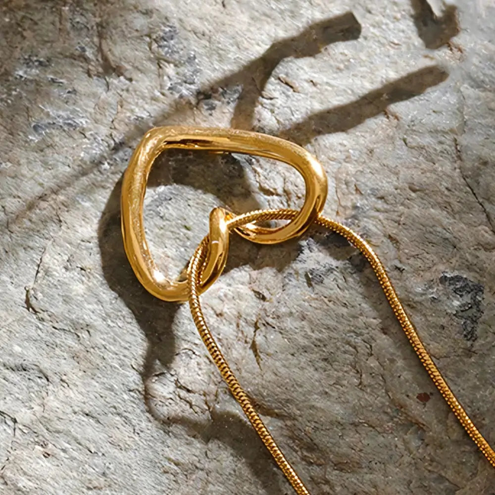 Colar Feminino Dourado de coração com corrente rabo de rato Amélia sobre fundo claro com brilho delicado