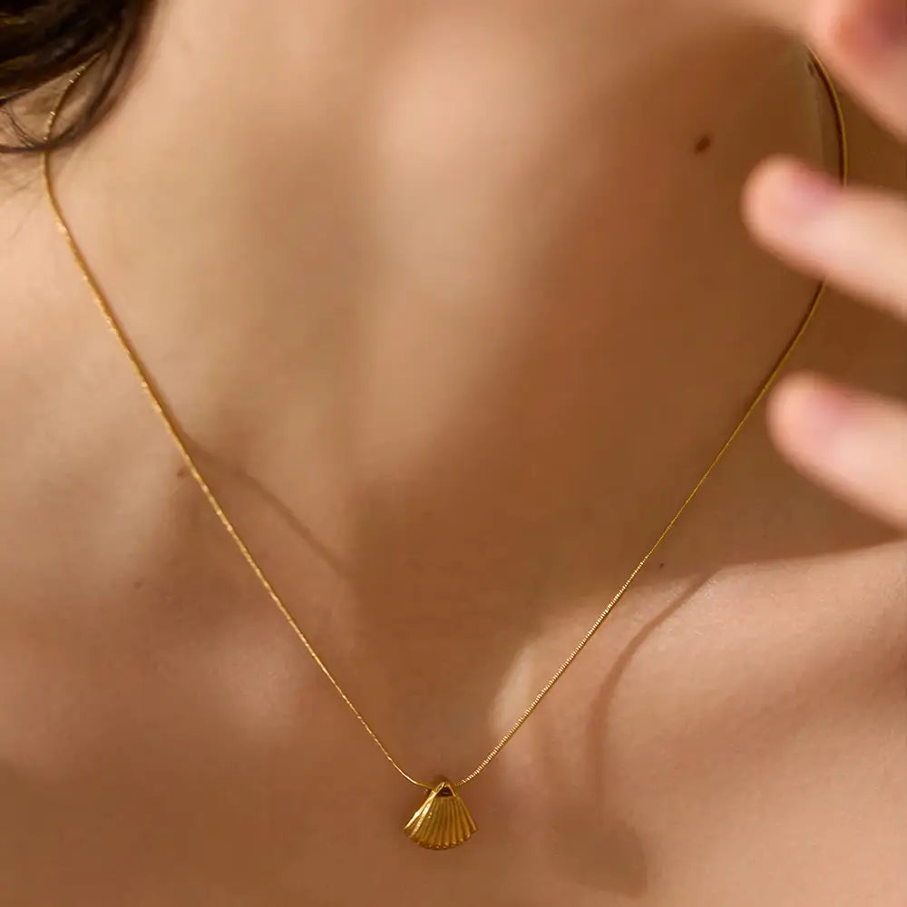 Colar Feminino Dourado de corrente rabo de rato com pingente concha, caimento leve e textura polida