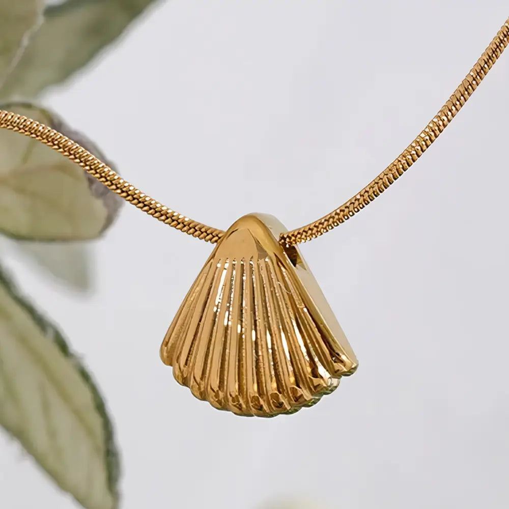 Colar Feminino Dourado de corrente rabo de rato com pingente concha Maris em cenário neutro e iluminação suave