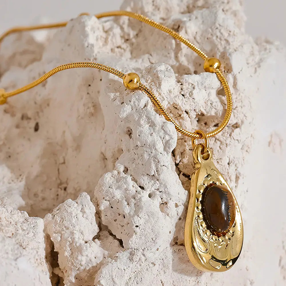 Colar Feminino Dourado de corrente rabo de rato com pingente e pedra tigre em ambiente clean e tom natural