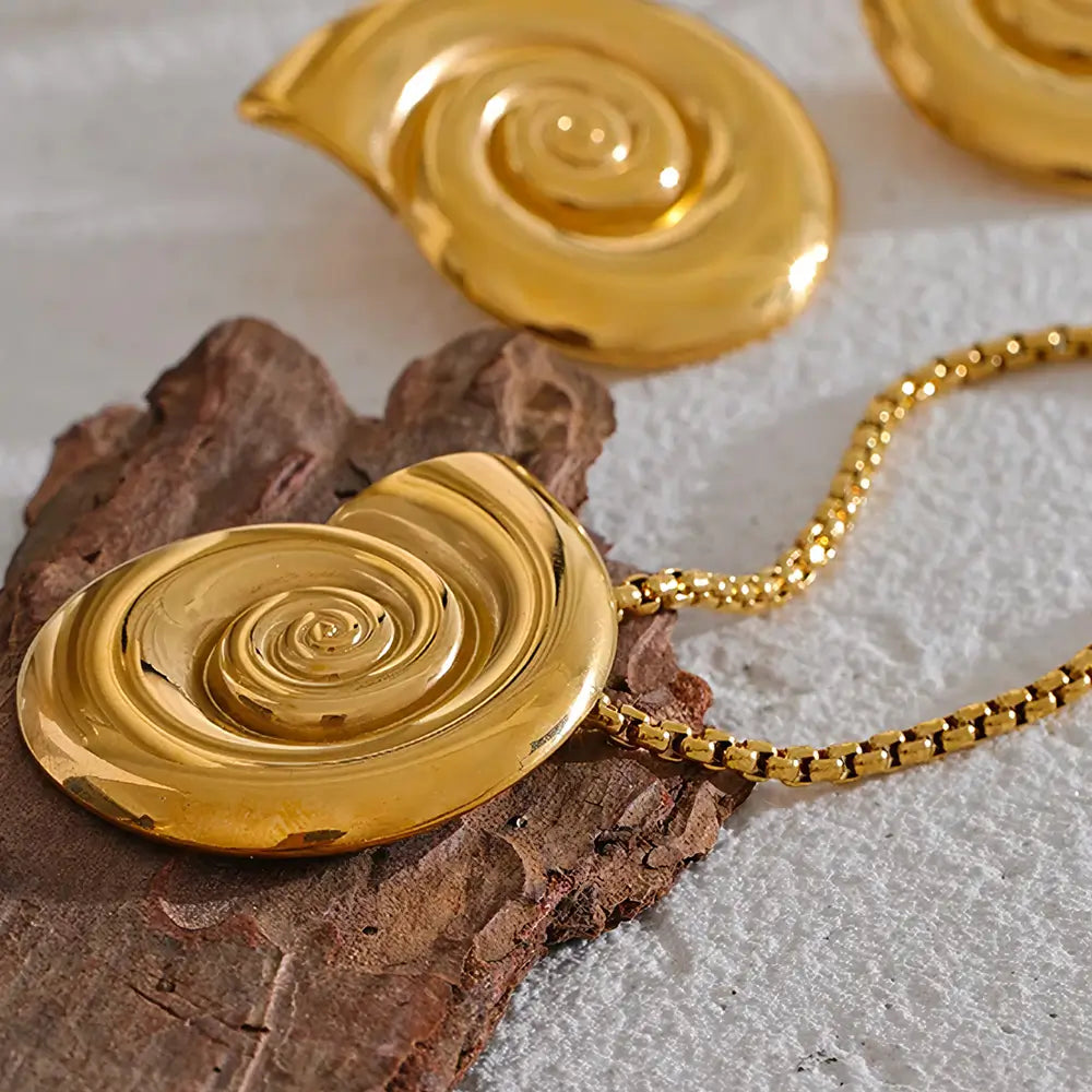 Colar Feminino Dourado de coração com concha natural Marena sobre fundo neutro e iluminação suave