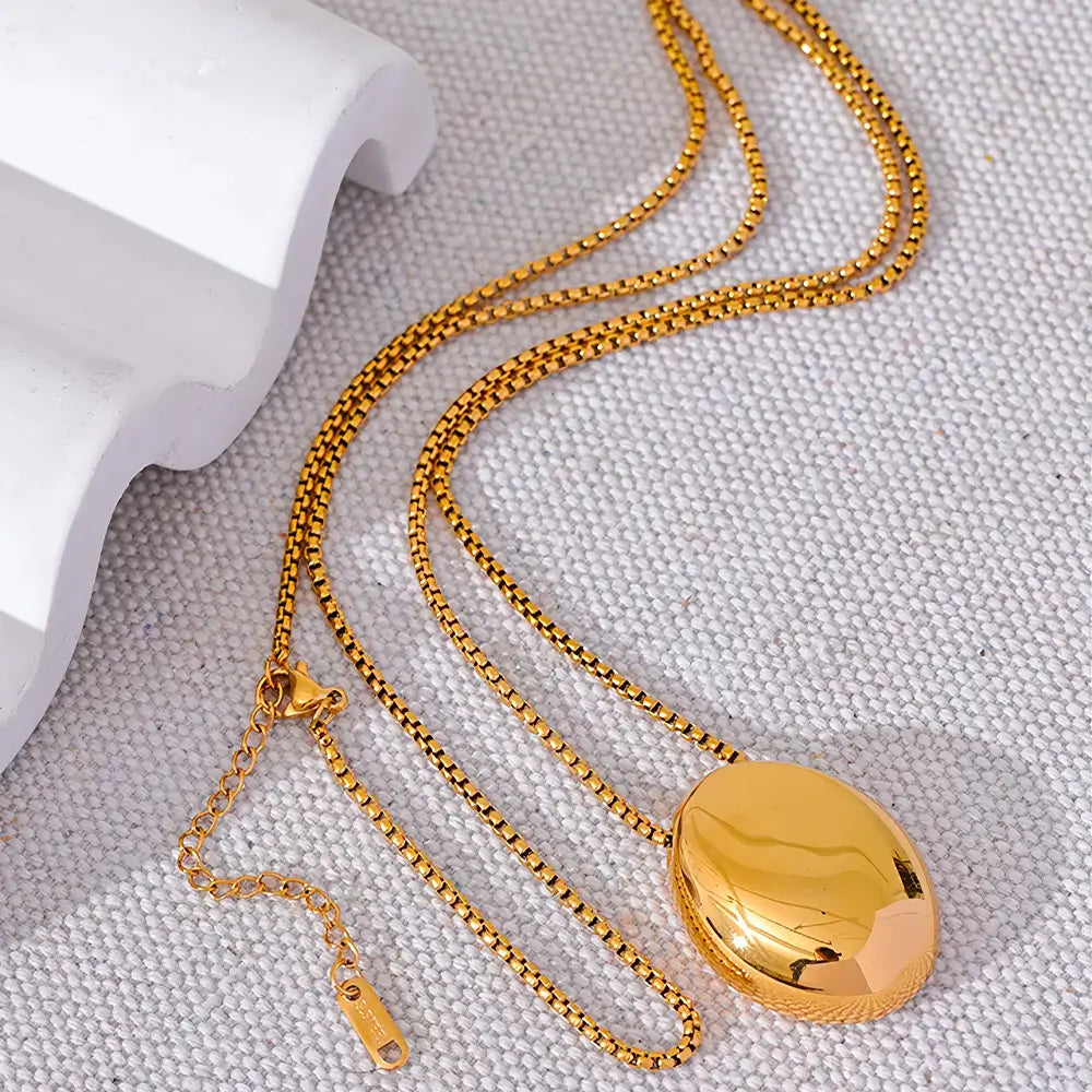 Colar Feminino Dourado de Corrente Veneziana longo com pingente oval Liora em fundo neutro clean