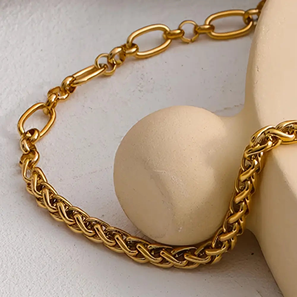 Colar Feminino Dourado de corrente grossa e mista Thessa em fundo neutro e composição minimalista