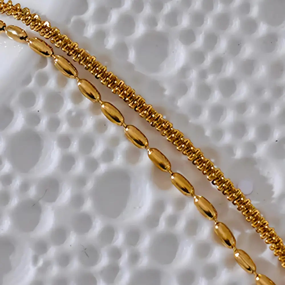 Colar Feminino Dourado duplo corrente torcida e contas Elara em fundo neutro com iluminação suave