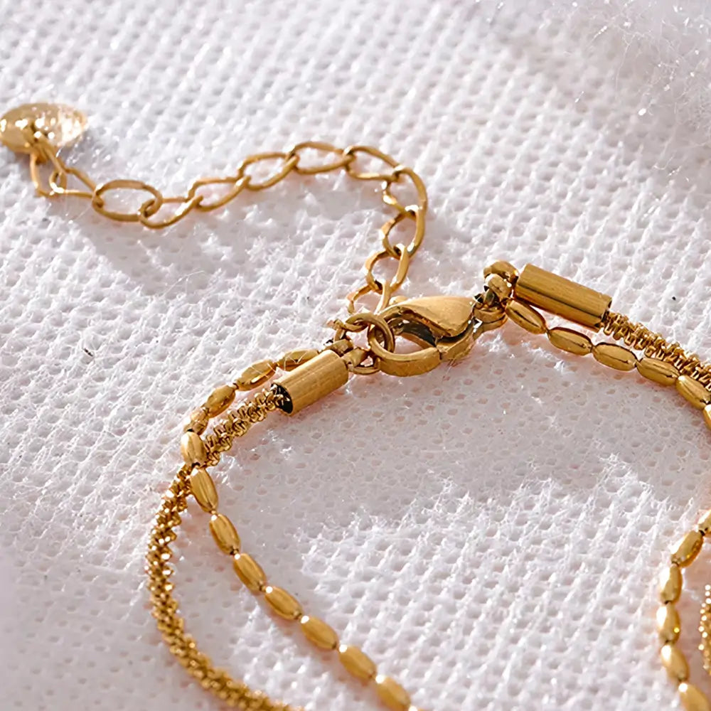 Colar Feminino Dourado duplo corrente torcida e contas Elara, textura refinada em ambiente clean
