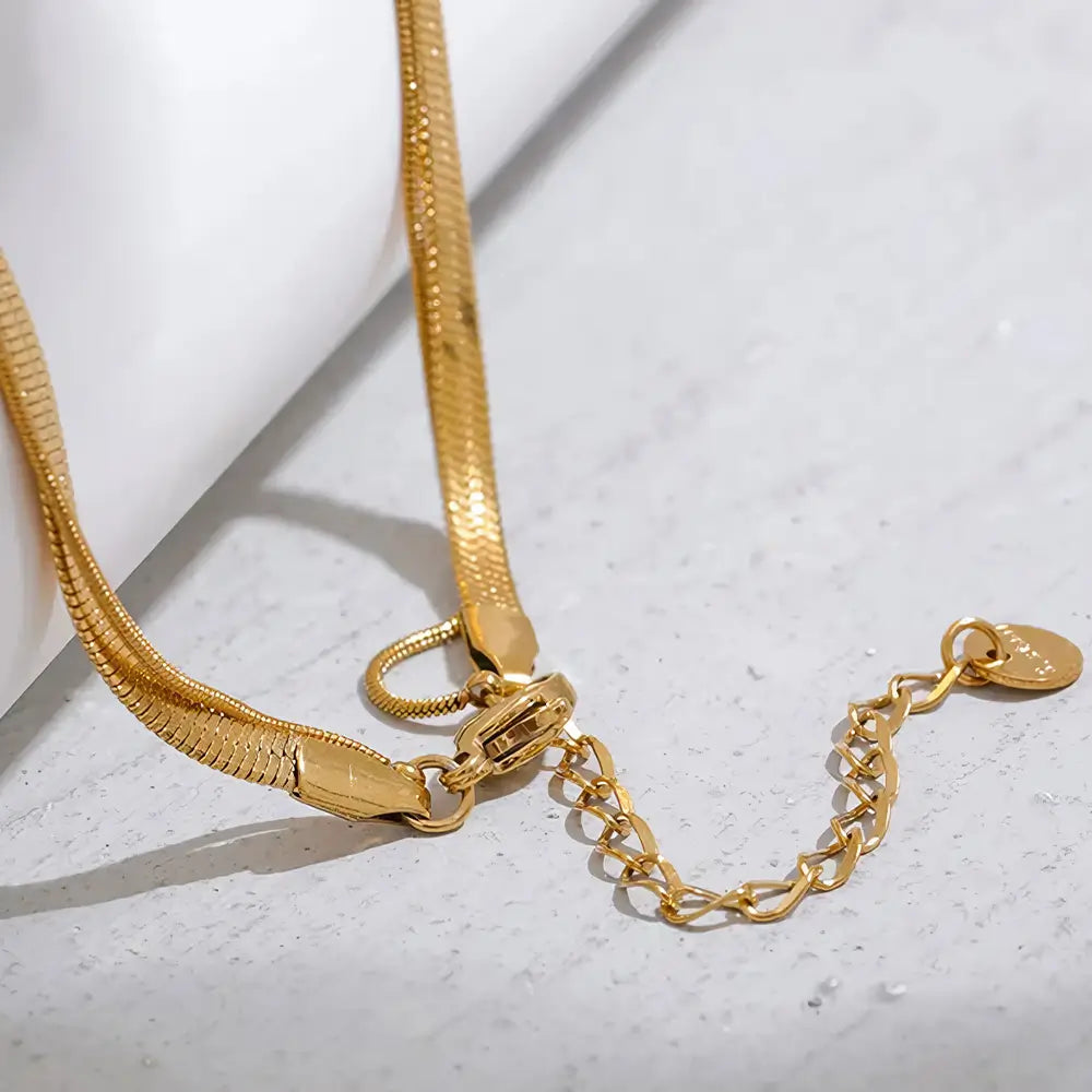 Colar Feminino Dourado duplo malha snake e rabo de rato com pingente oval Dalia em cenário minimalista