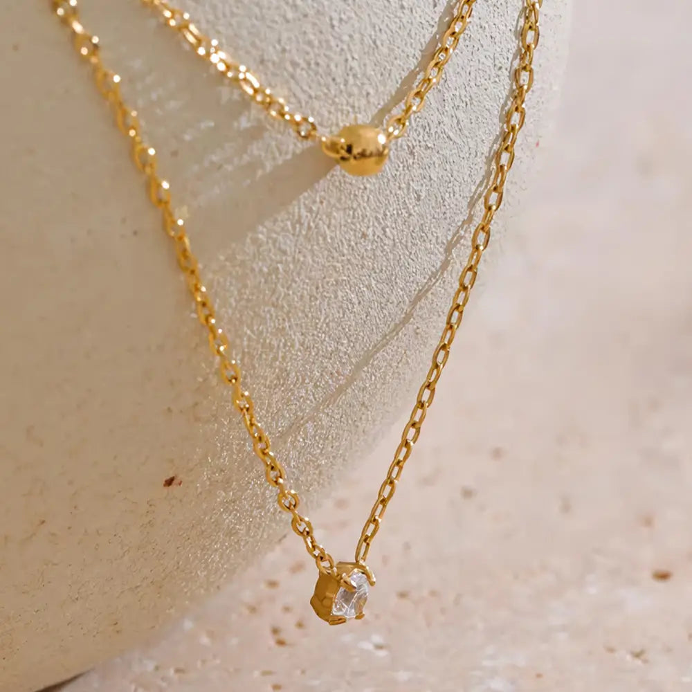 Colar Feminino Dourado duplo ponto de luz com zircônia Liora, delicadeza em cenário neutro e suave