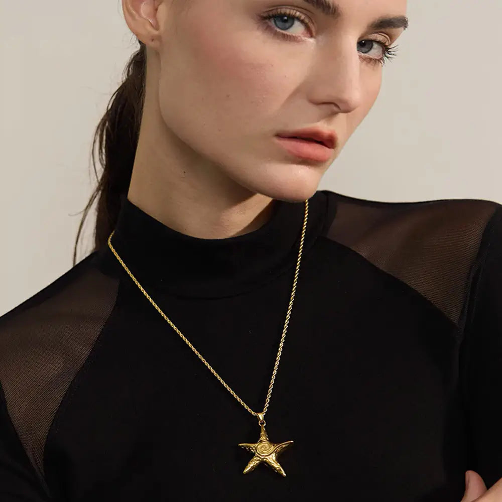 Mulher usando o Colar Feminino Dourado Longo Cordão Baiano com Pingente Estrela do Mar Marella - Banhado a Ouro 18k