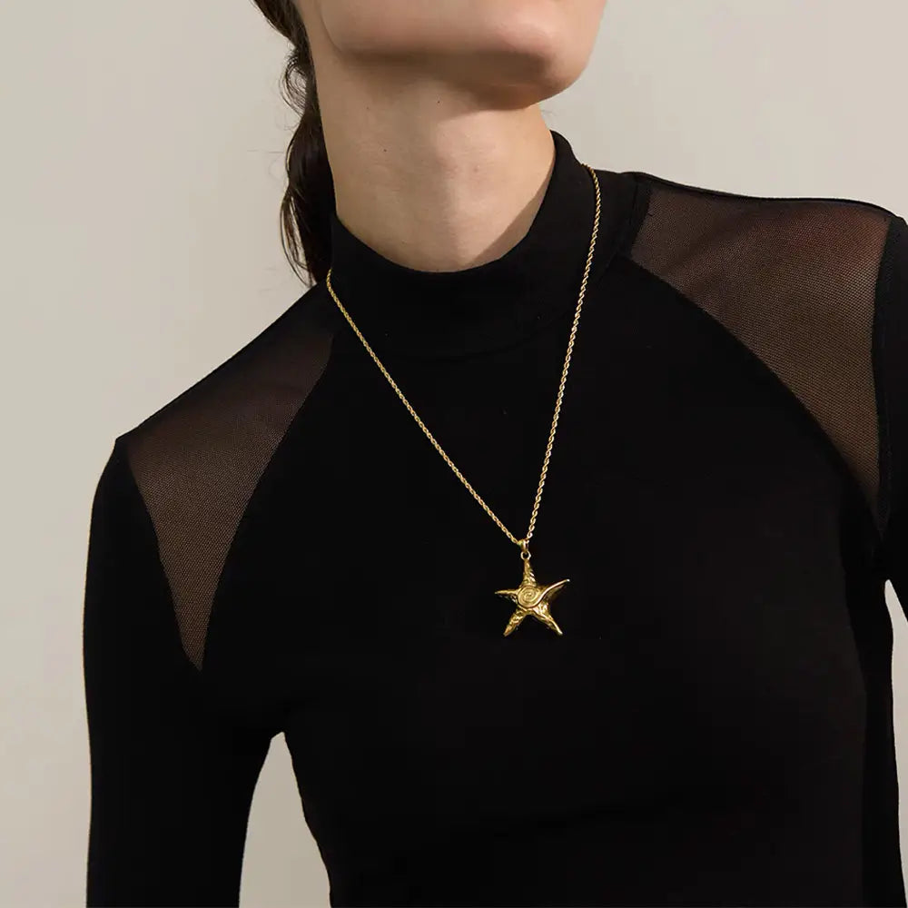 Mulher usando o Colar Feminino Dourado Longo Cordão Baiano com Pingente Estrela do Mar Marella - Banhado a Ouro 18k