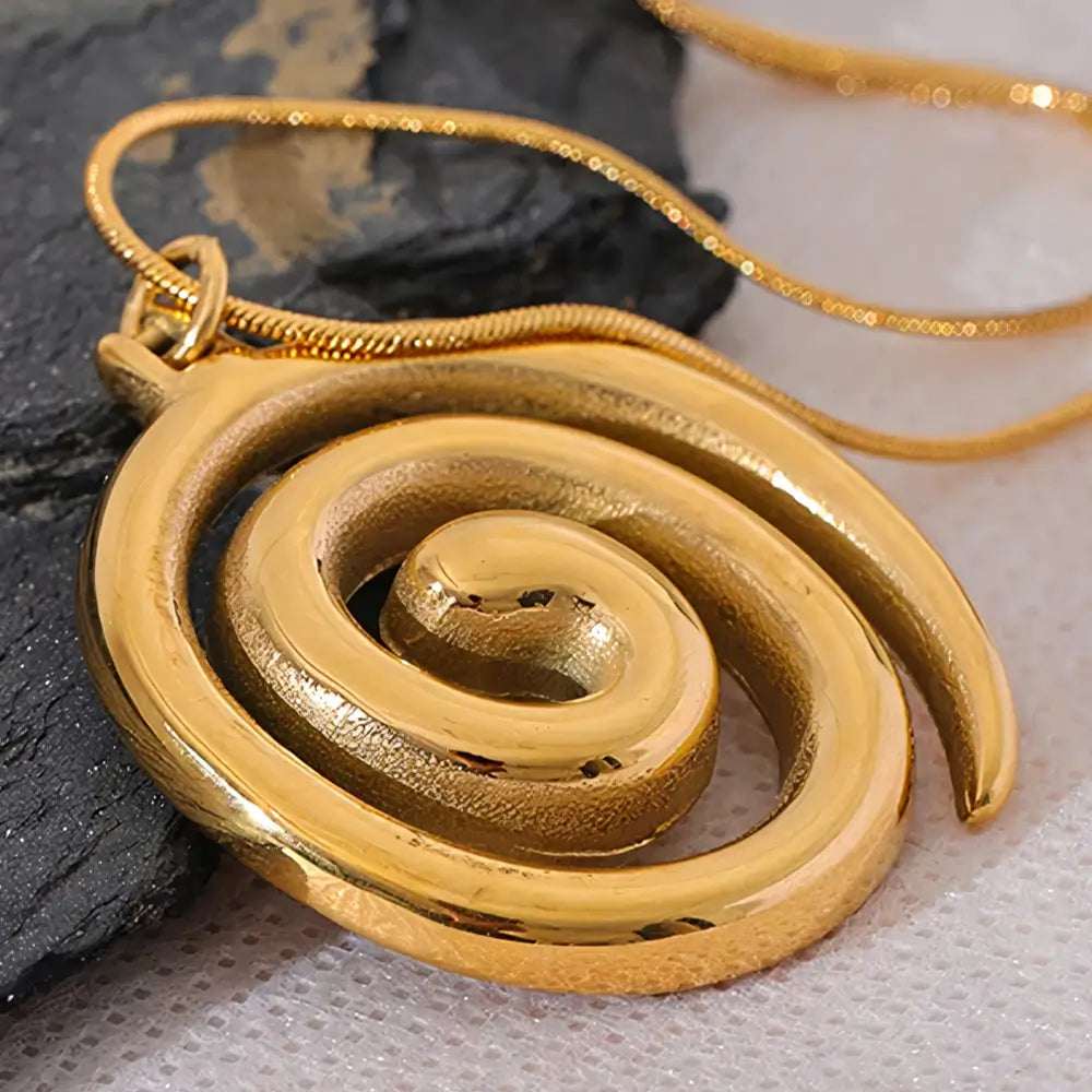 Colar Feminino Dourado rabo de rato com brilho sutil e espiral dourada em cenário minimalista