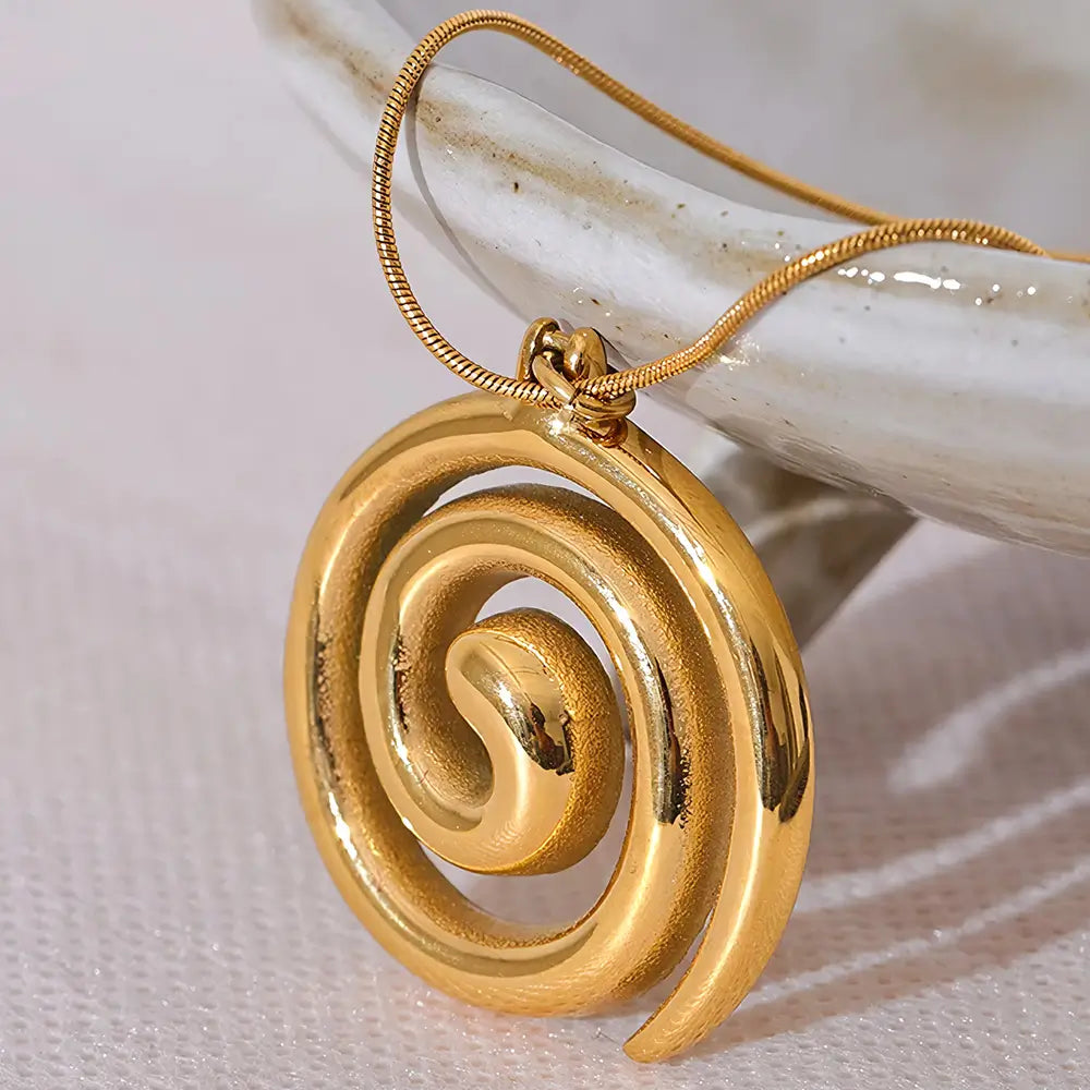 Colar Feminino Dourado rabo de rato com pingente espiral Serena em fundo neutro e iluminação suave