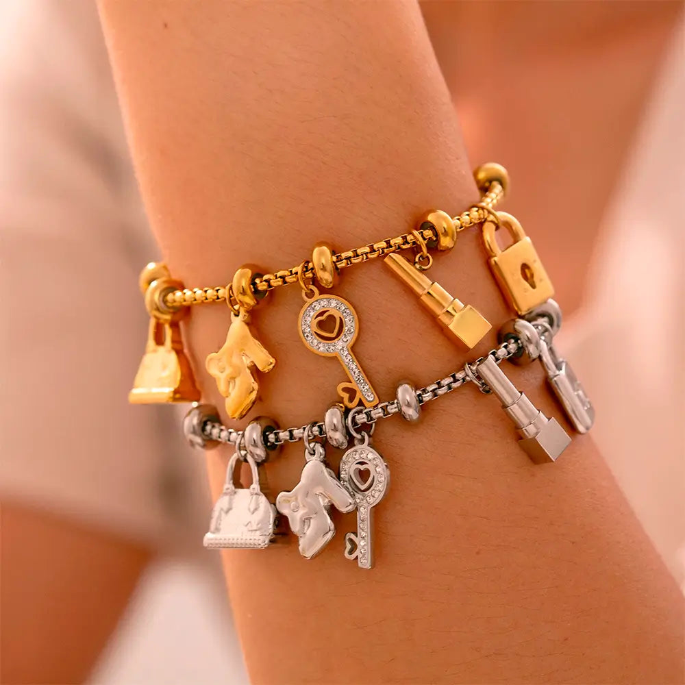 Pulseira Berloques em Aço Inox Dourada e prata Feminina de Cadeado, Bolsa, Batom e Chave Luxelle - Banhada a Ouro 18k, foto no braço