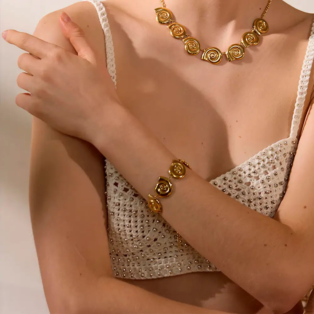 Foto de média distância de uma Mulher usando a Pulseira Feminina Dourada Conchas de Caracol Sirena - Banhada a Ouro 18k