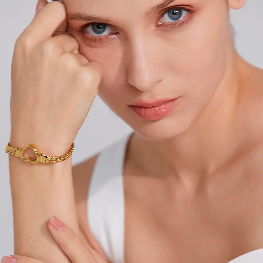 Modelo feminina usando a Pulseira Feminina Dourada Corrente Cubana Coração Amélie - Banhada a Ouro 18k