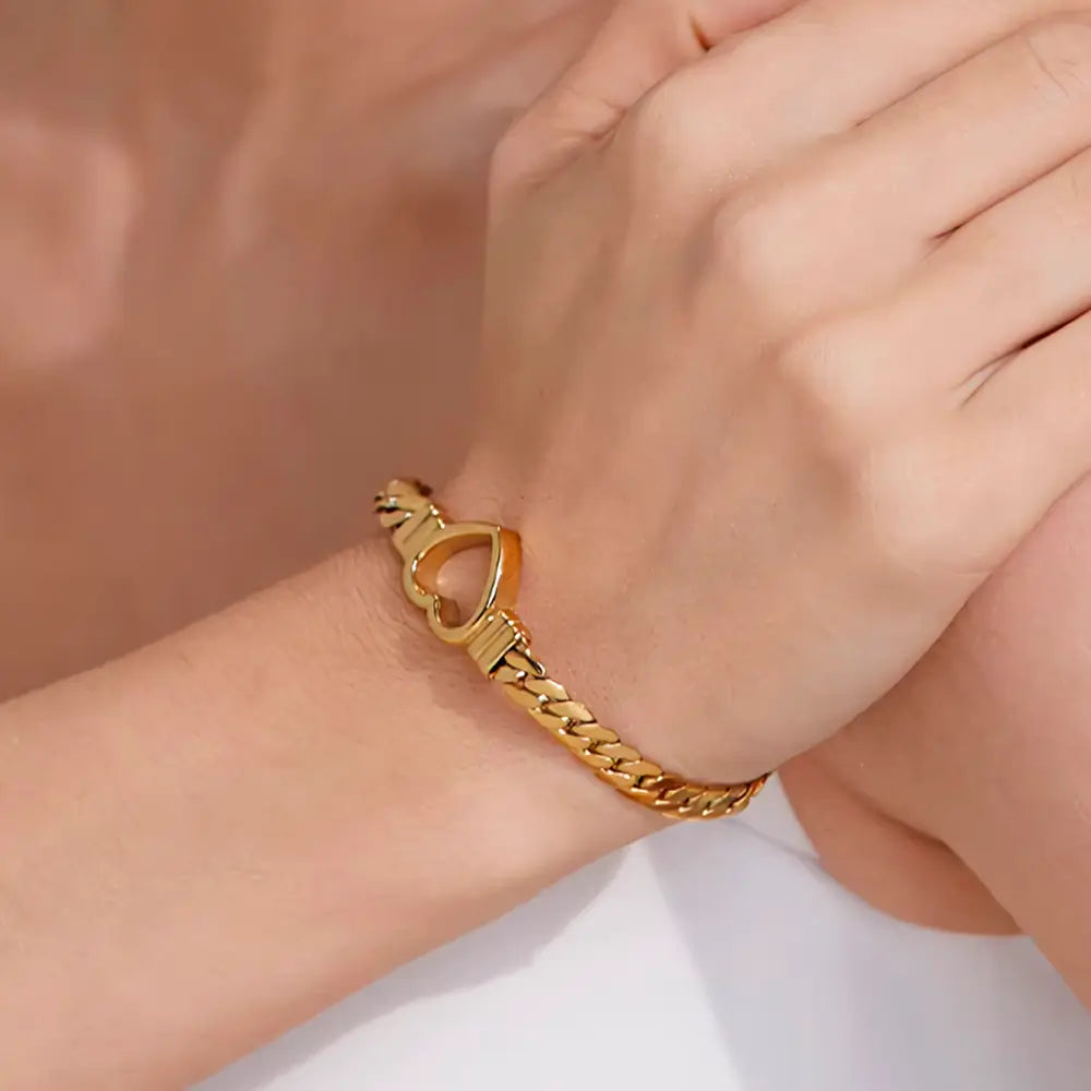 Foto de perto da Mulher usando a Pulseira Feminina Dourada Corrente Cubana Coração Amélie - Banhada a Ouro 18k