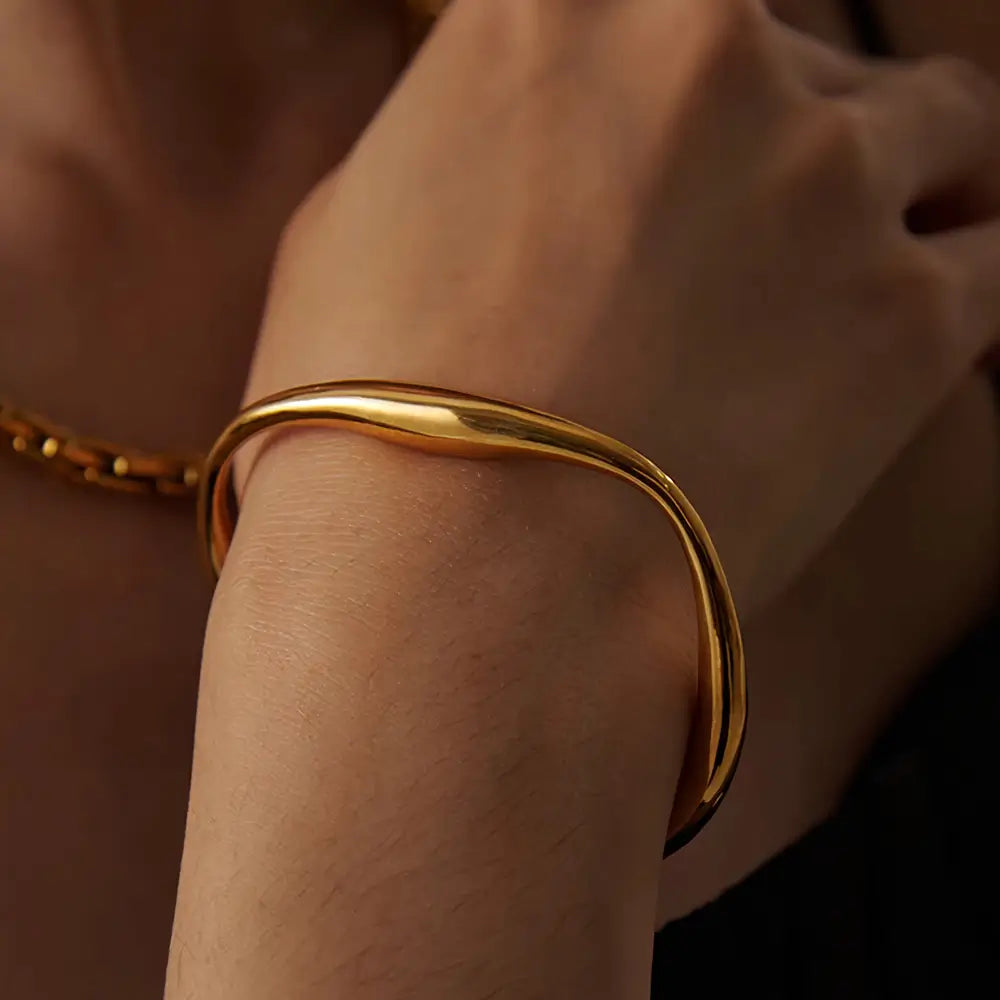 Foto de perto de uma Modelo usando a Pulseira Feminina Dourada Cuff Irregular Ajustável Aurora - Banhada a Ouro 18k