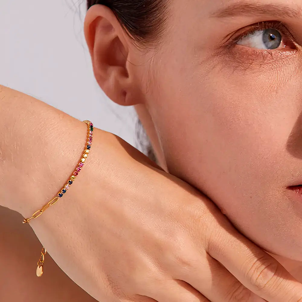 Foto de perto de uma Mulher usando a Pulseira Feminina Dourada de Elos Retangulares e Zircônias Tingidas Liora - Banhada a Ouro 18k