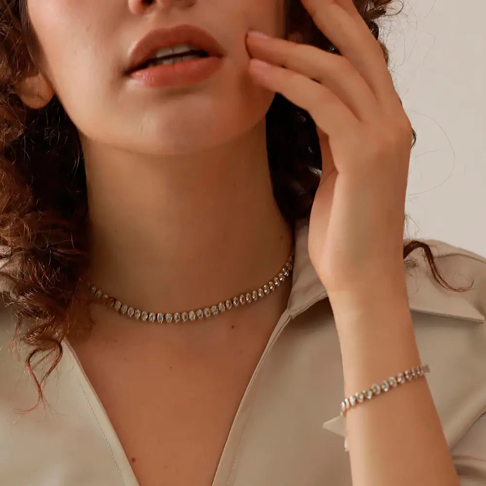 Modelo usando a Pulseira Feminina Dourada de Zircônias Cúbicas Évora - Banhada a Ouro 18k, foto de perto mão esquerda