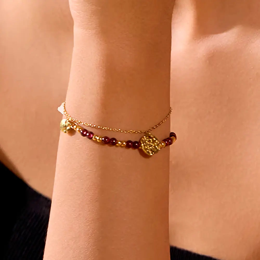 Foto de perto de uma Mulher usando a Pulseira Feminina Dourada Dupla de Pedras Naturais e Pingentes Aurélianne - Banhada a Ouro 18k