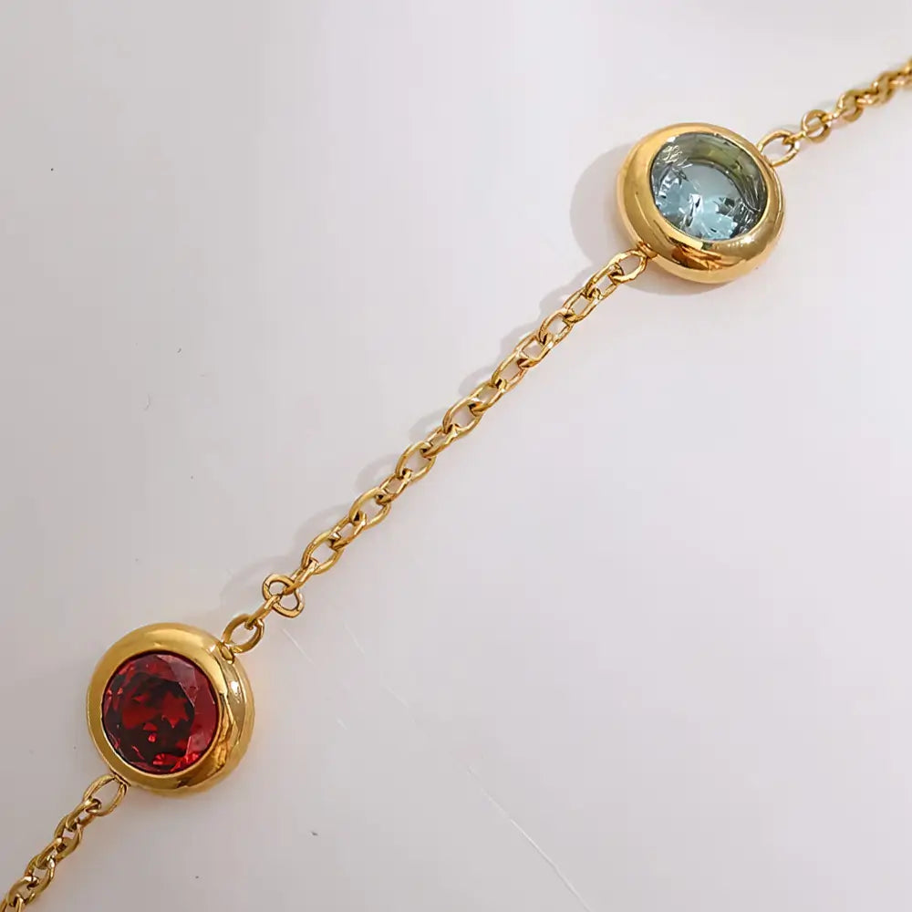 Foto dos detalhes da Pulseira Feminina Dourada de Elos e Zircônias Tingidas Mirella - Banhada a Ouro 18k, fundo neutro