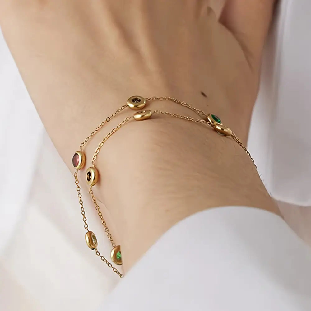 Foto de perto do braço de uma Mulher usando a Pulseira Feminina Dourada de Elos e Zircônias Tingidas Mirella - Banhada a Ouro 18k