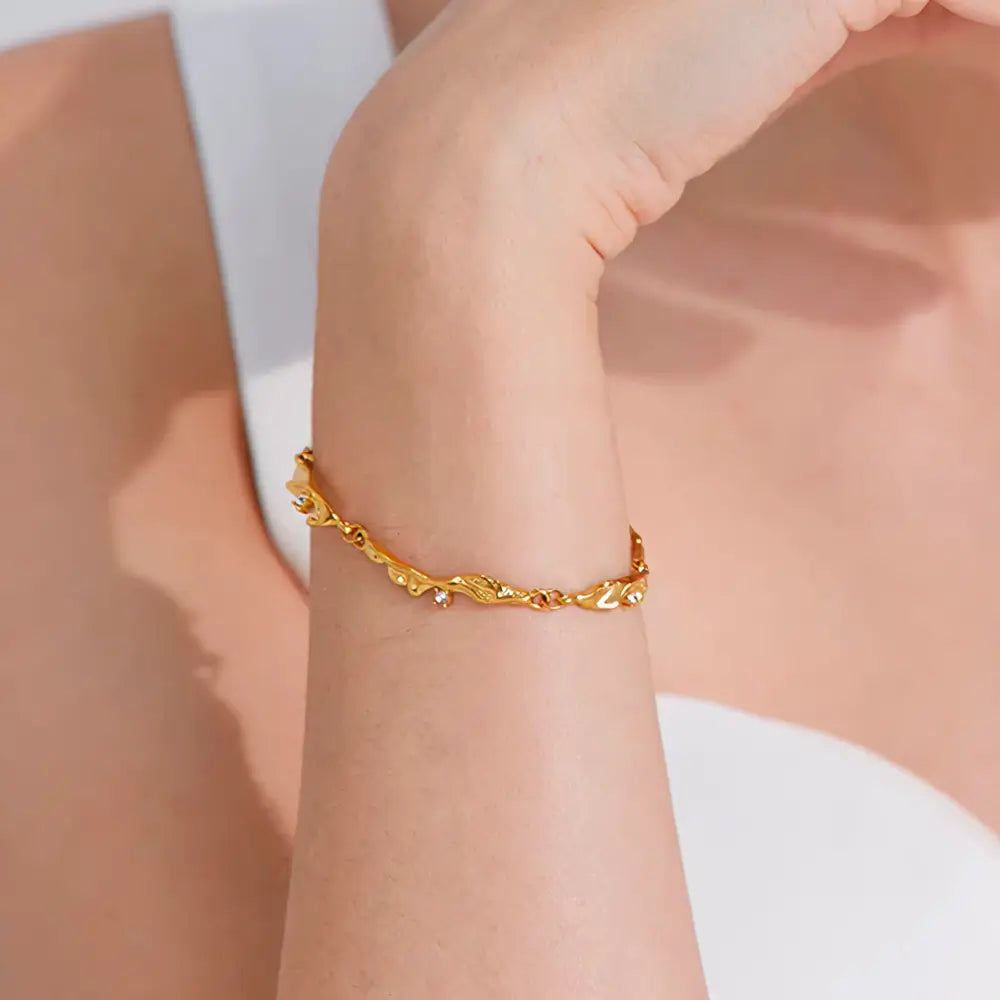 Foto próxima da Mulher usando a Pulseira Feminina Dourada Ondas com Zircônias Cúbicas Elara - Banhada a Ouro 18k