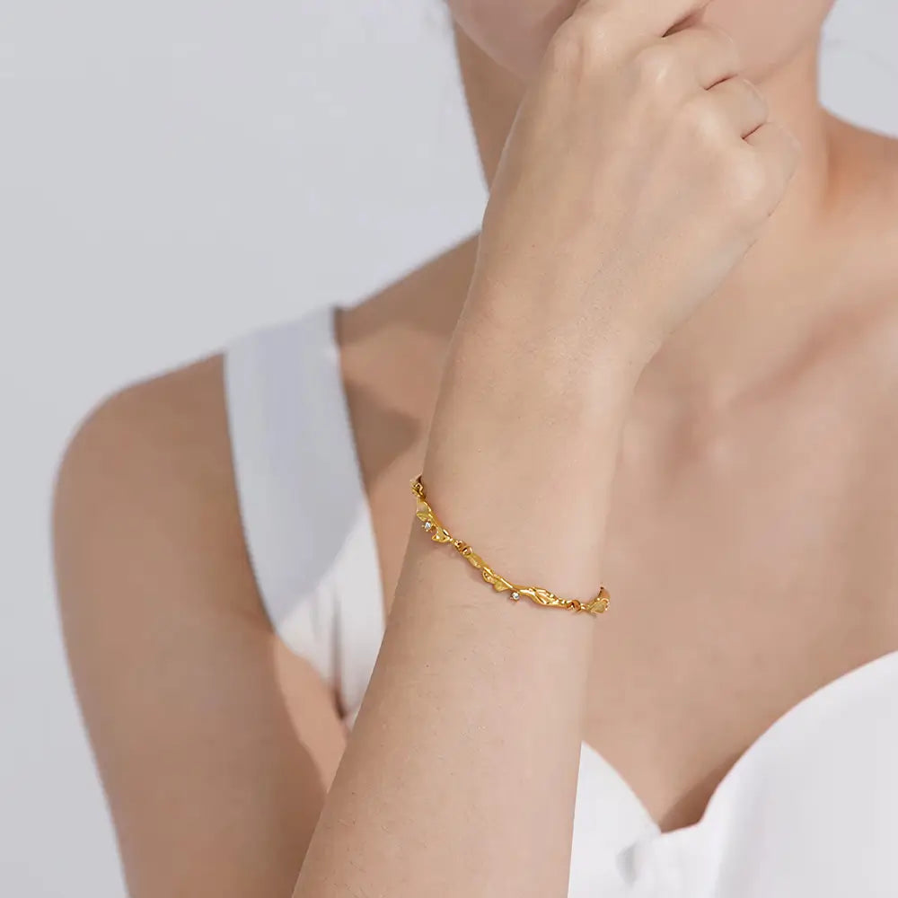 Foto do braço de uma Mulher usando a Pulseira Feminina Dourada Ondas com Zircônias Cúbicas Elara - Banhada a Ouro 18k