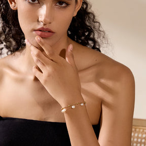 Foto distante da modelo usando a Pulseira Feminina Dourada de Pérolas Naturais Dupla - Banhada a Ouro 18k