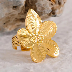 Anel Feminino Dourado Flor de 5 Pétalas Ajustável Florença - Banhado  a Ouro 18k, foto em um fundo neutro 