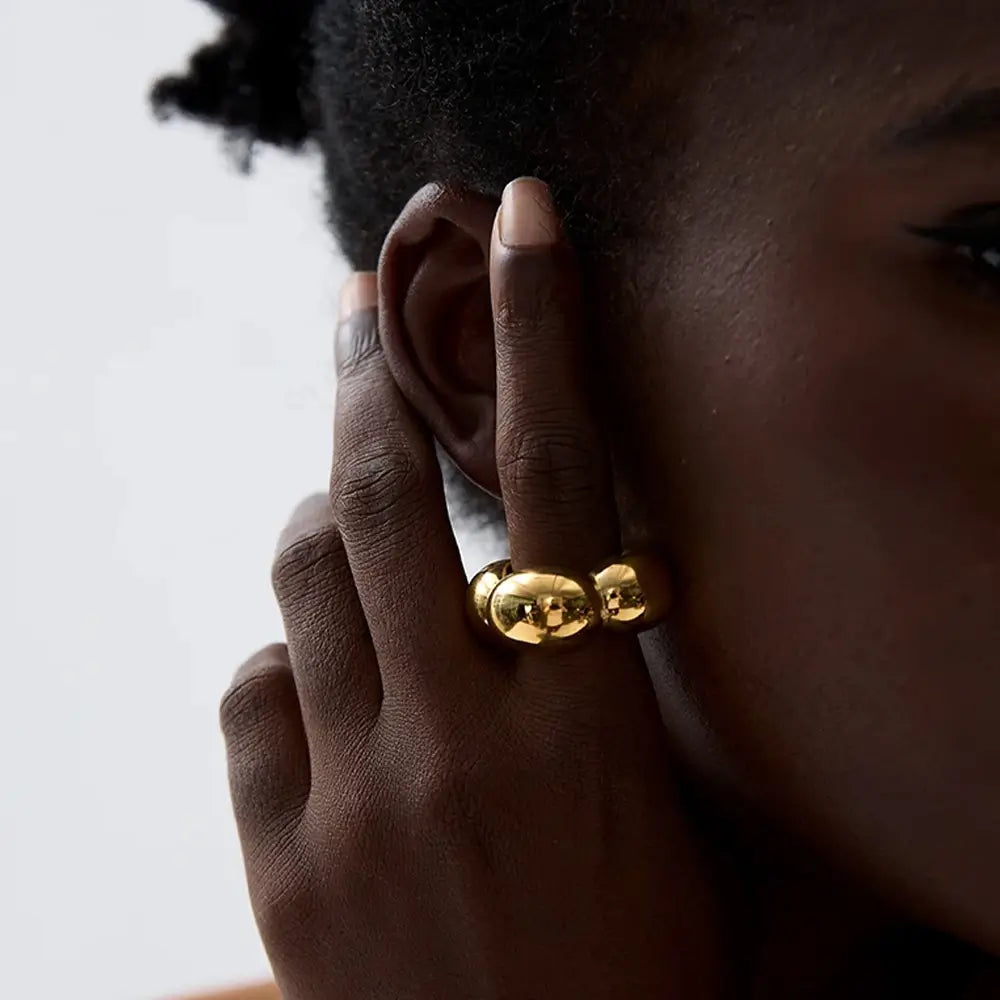 Mulher usando o Anel Feminino Dourado Flor Oca Fiorella - Banhado a Ouro 18k, foto de perto