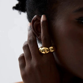 Mulher usando o Anel Feminino Dourado Flor Oca Fiorella - Banhado a Ouro 18k, foto de perto