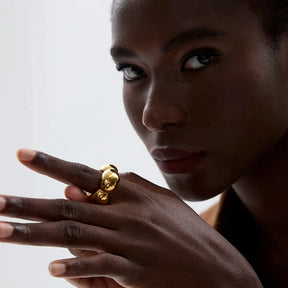Mulher usando o Anel Feminino Dourado Flor Oca Fiorella - Banhado a Ouro 18k, foto de perto da mão